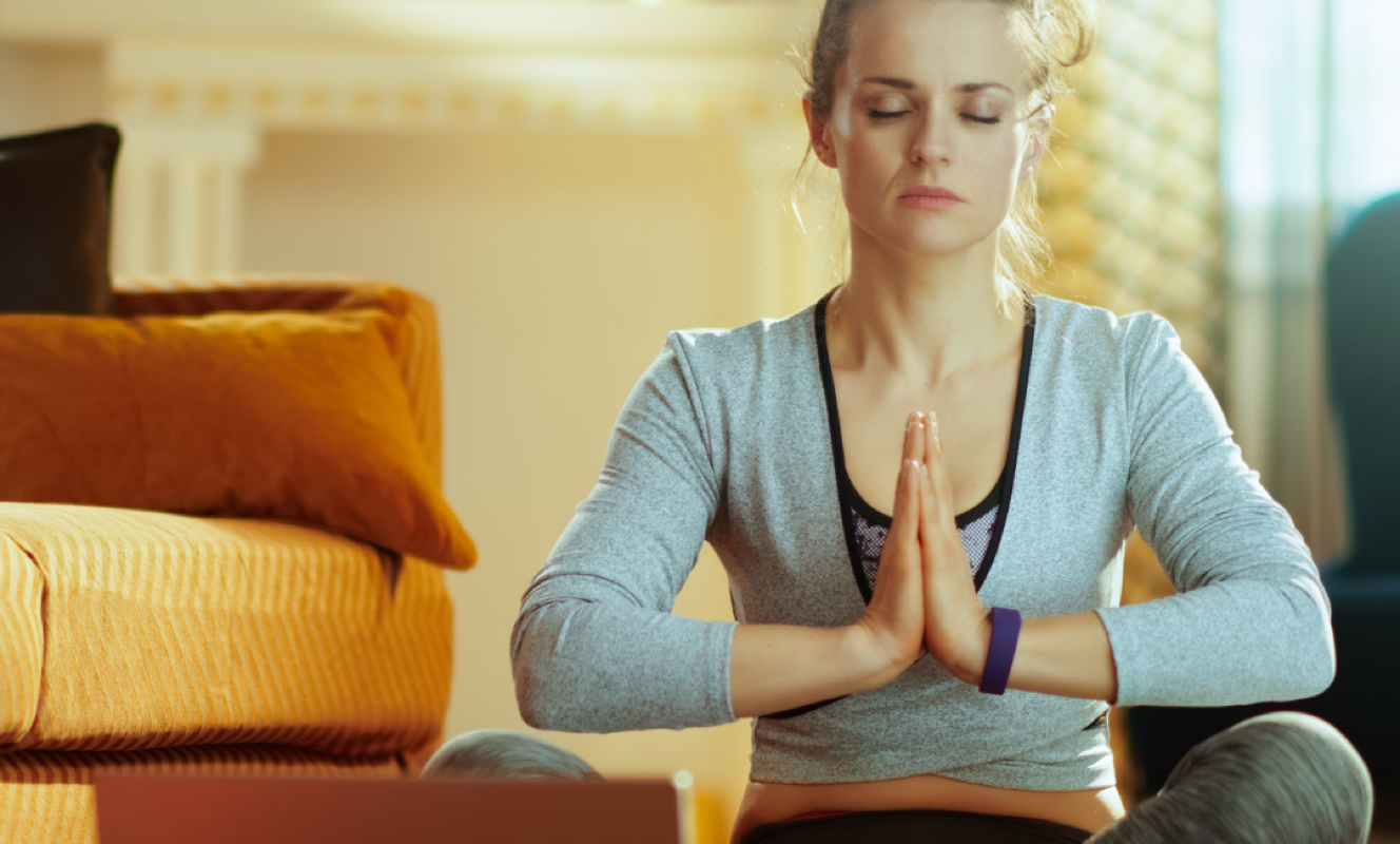 Woman mediating with hands in prayer at heart